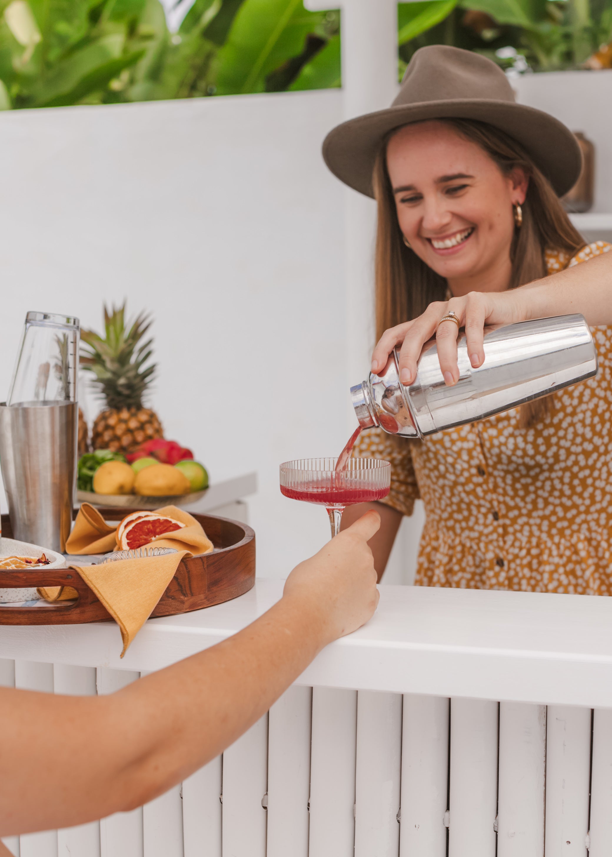 a lady pouring a cocktail she made with her gin cocktail subscription box, that is delivered Australia wide.